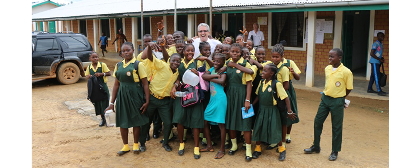 Eric Kellerer poses with a group of Liberian grade school students