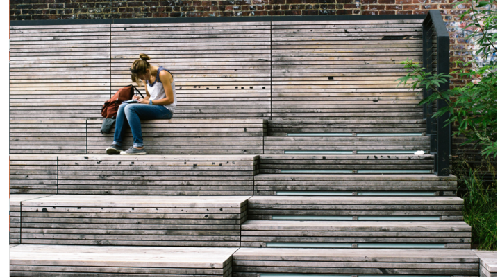 A student sits on steps studying outside