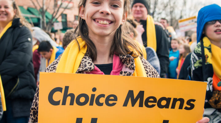 A student holds up a sign that says "Choice Means Hope" for National School Choice Week