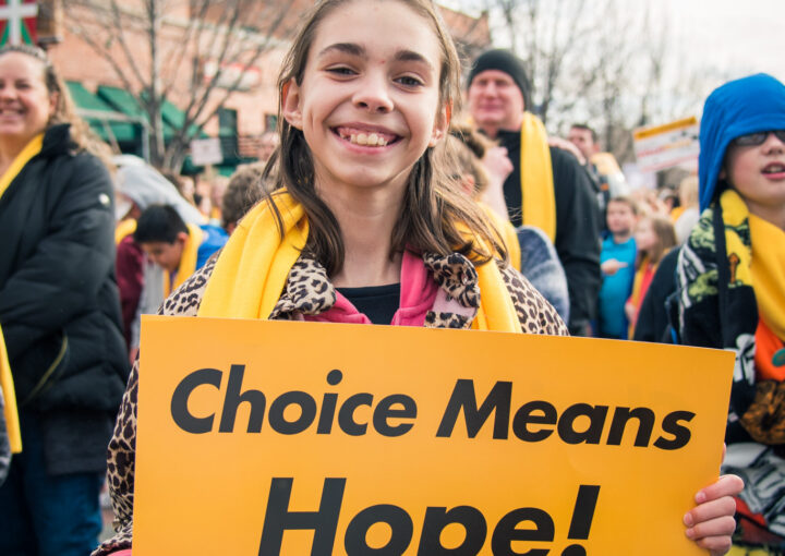 A student holds up a sign that says "Choice Means Hope" for National School Choice Week