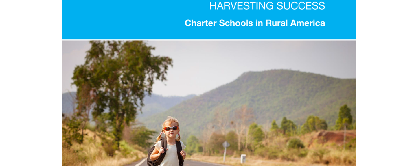 A little girl wearing red sunglasses walks down a road with her backpack on