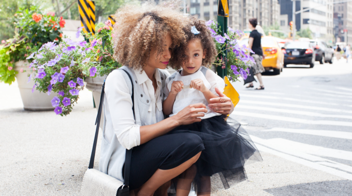 A mom sits down and embraces her daughter