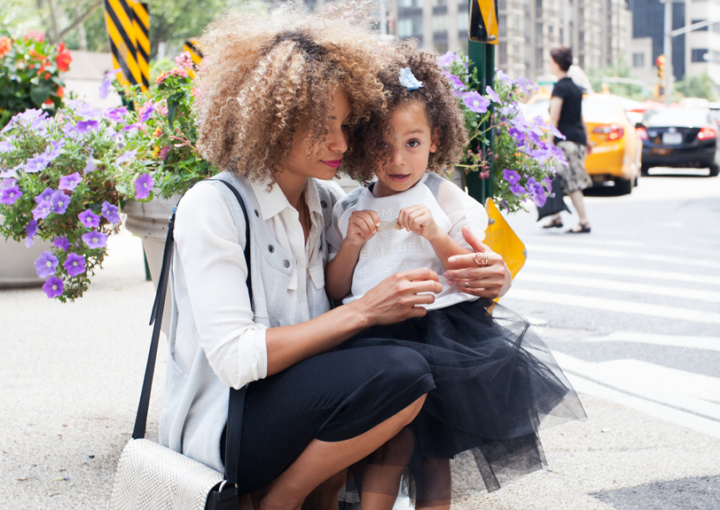 A mom sits down and embraces her daughter