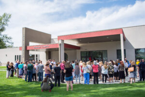A crowd of people watch the ribbon cutting at Idaho Arts Charter School