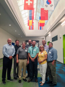 The Bluum team, Sage team and JKAF team stand together inside Sage International School of Boise