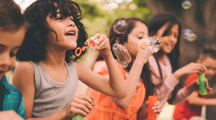Children blow bubbles outside