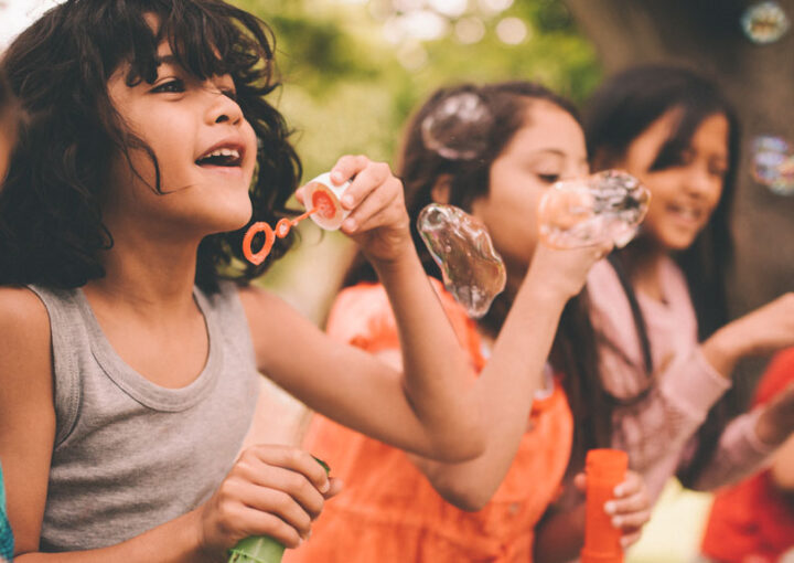 Children blow bubbles outside