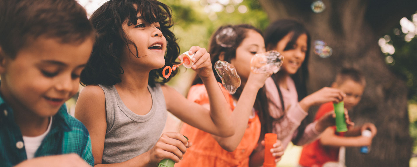 Children blow bubbles outside