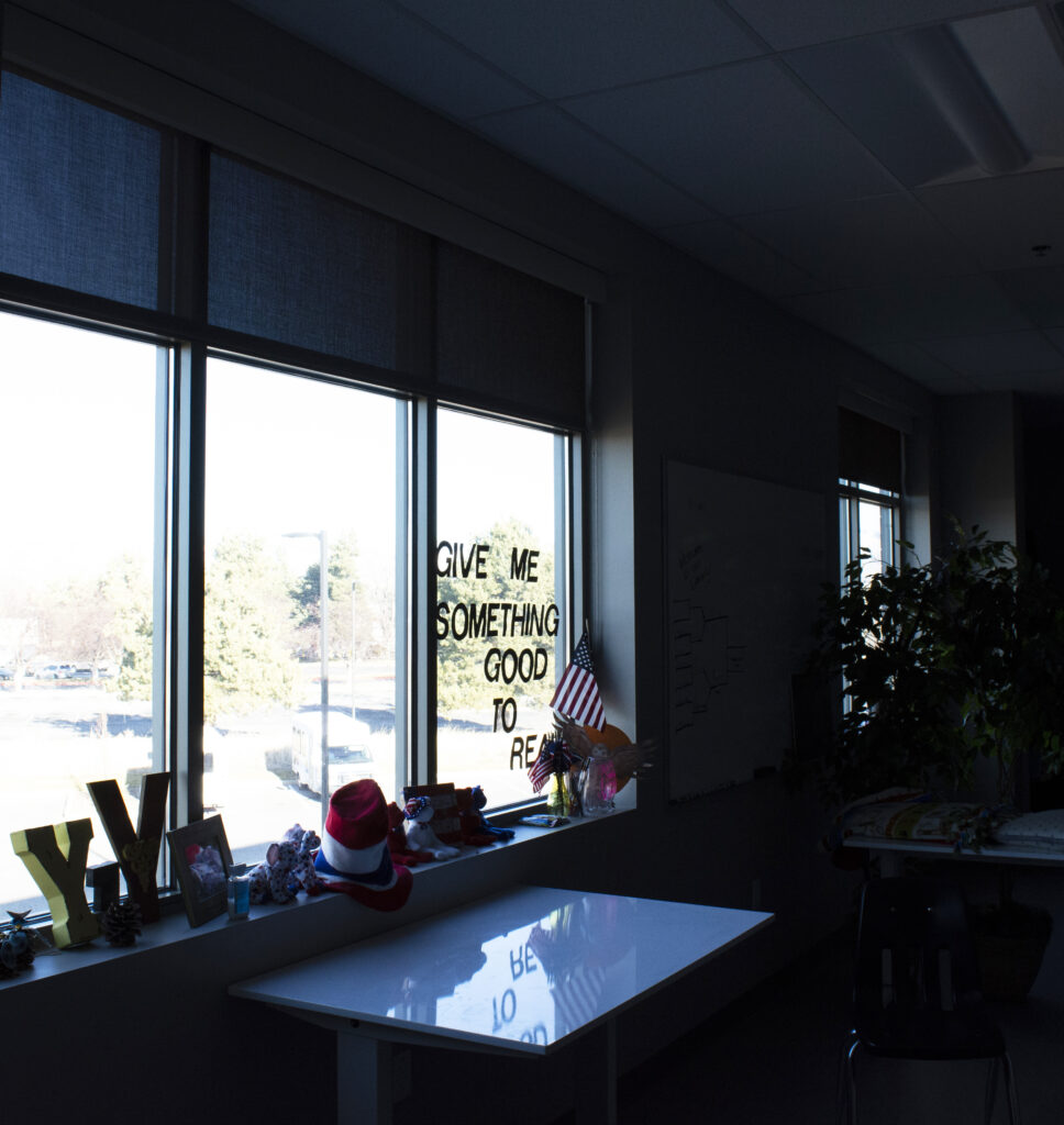 Give Me Something Good to Read is displayed on a window in a classroom