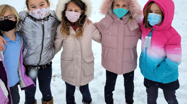 Kids stand outside by the playground at Rolling Hills Public Charter School