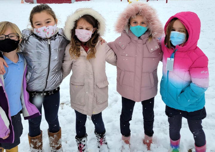 Kids stand outside by the playground at Rolling Hills Public Charter School