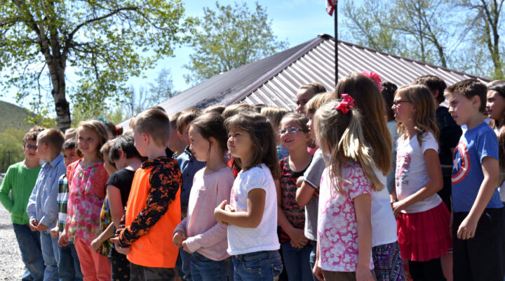 Kids who attend Upper Carmen Public Charter School stand outside the school