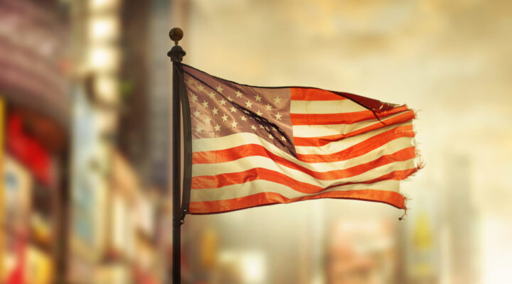 An American flag hangs with the edges torn