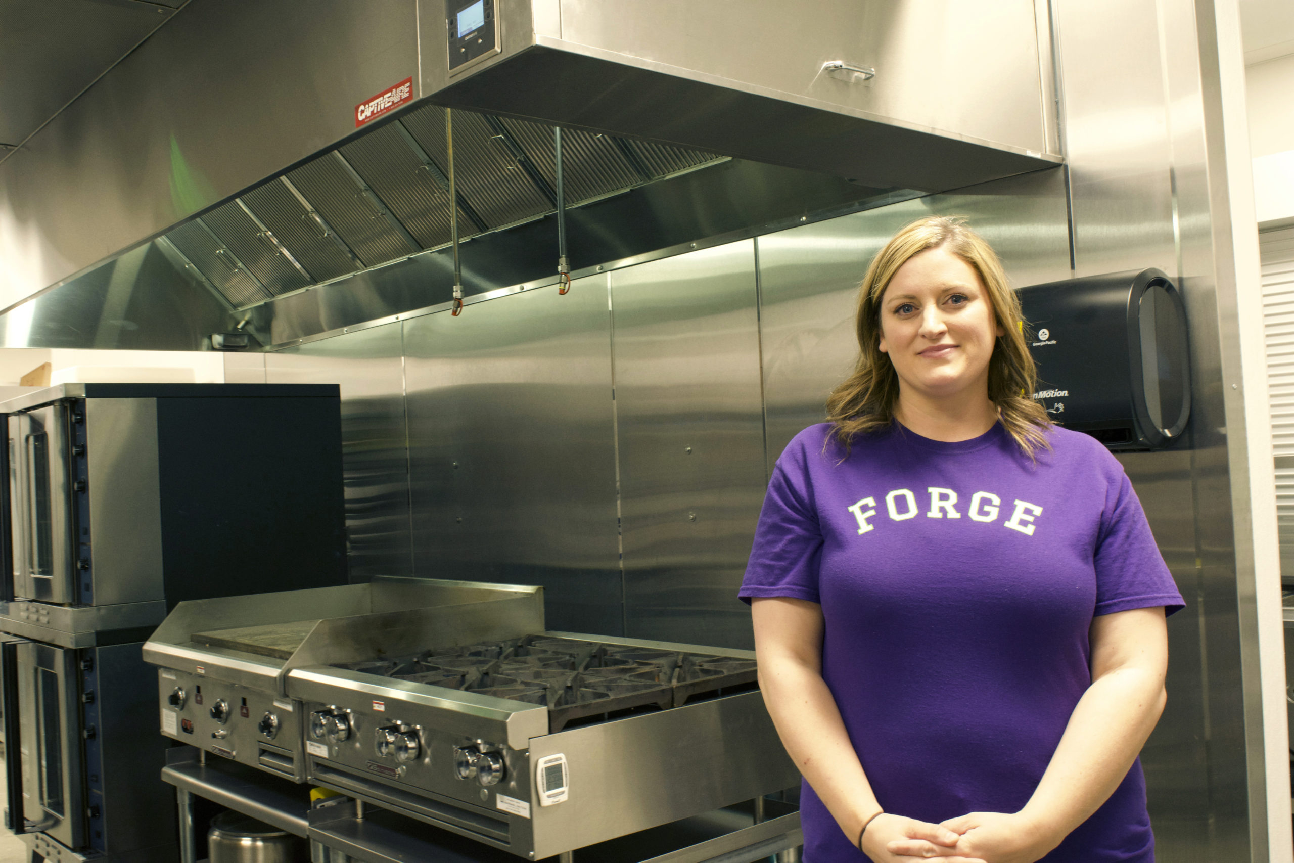 Monica Harshman stands in front of the stove in the Forge Kitchen