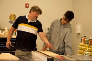 Construction Instructor Greg Cocozza helps a student in class
