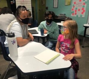 A teacher collaborates with students at Anser Charter School