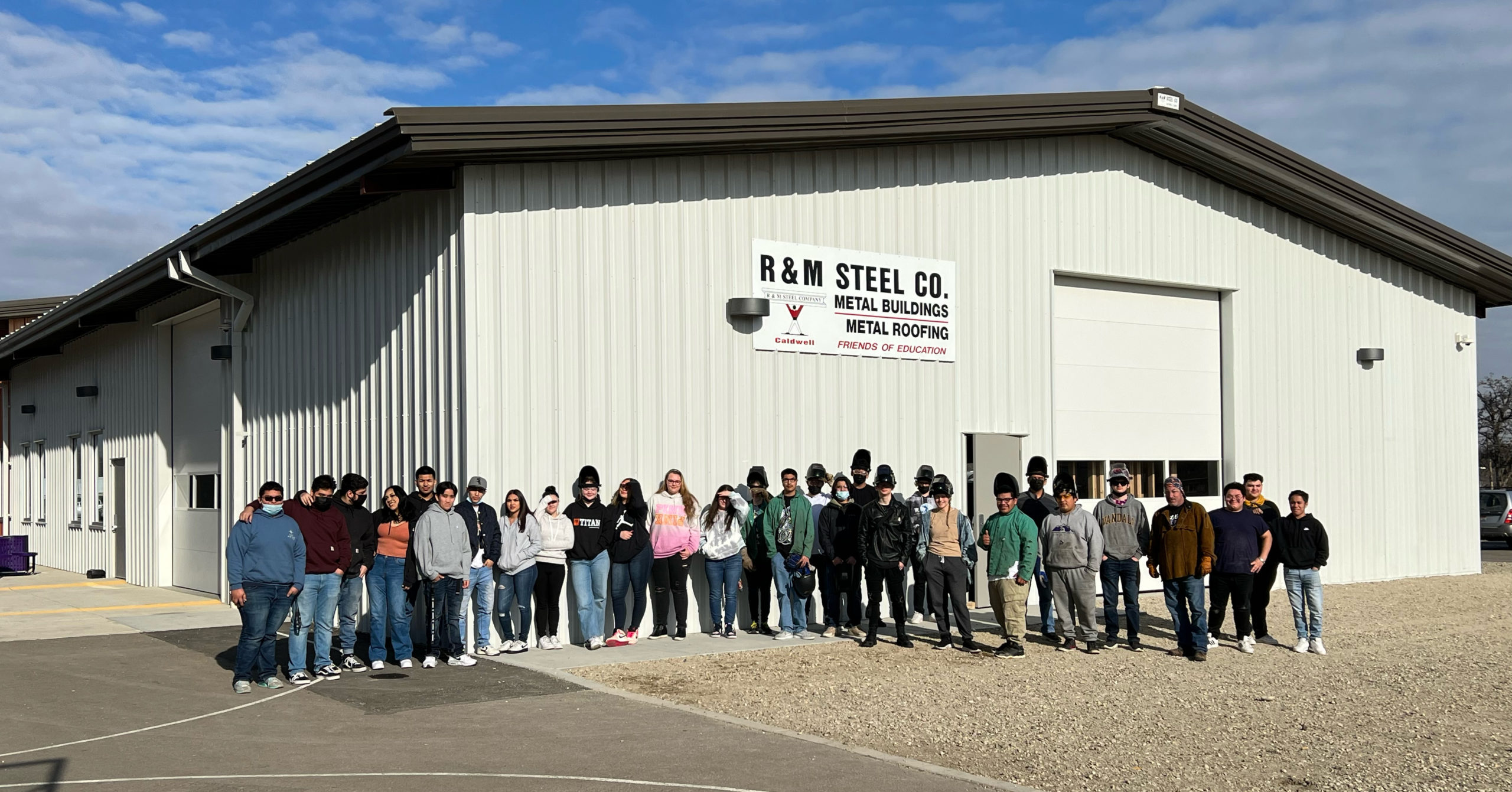 Students stand in front of their shop created by R&M Steel. 