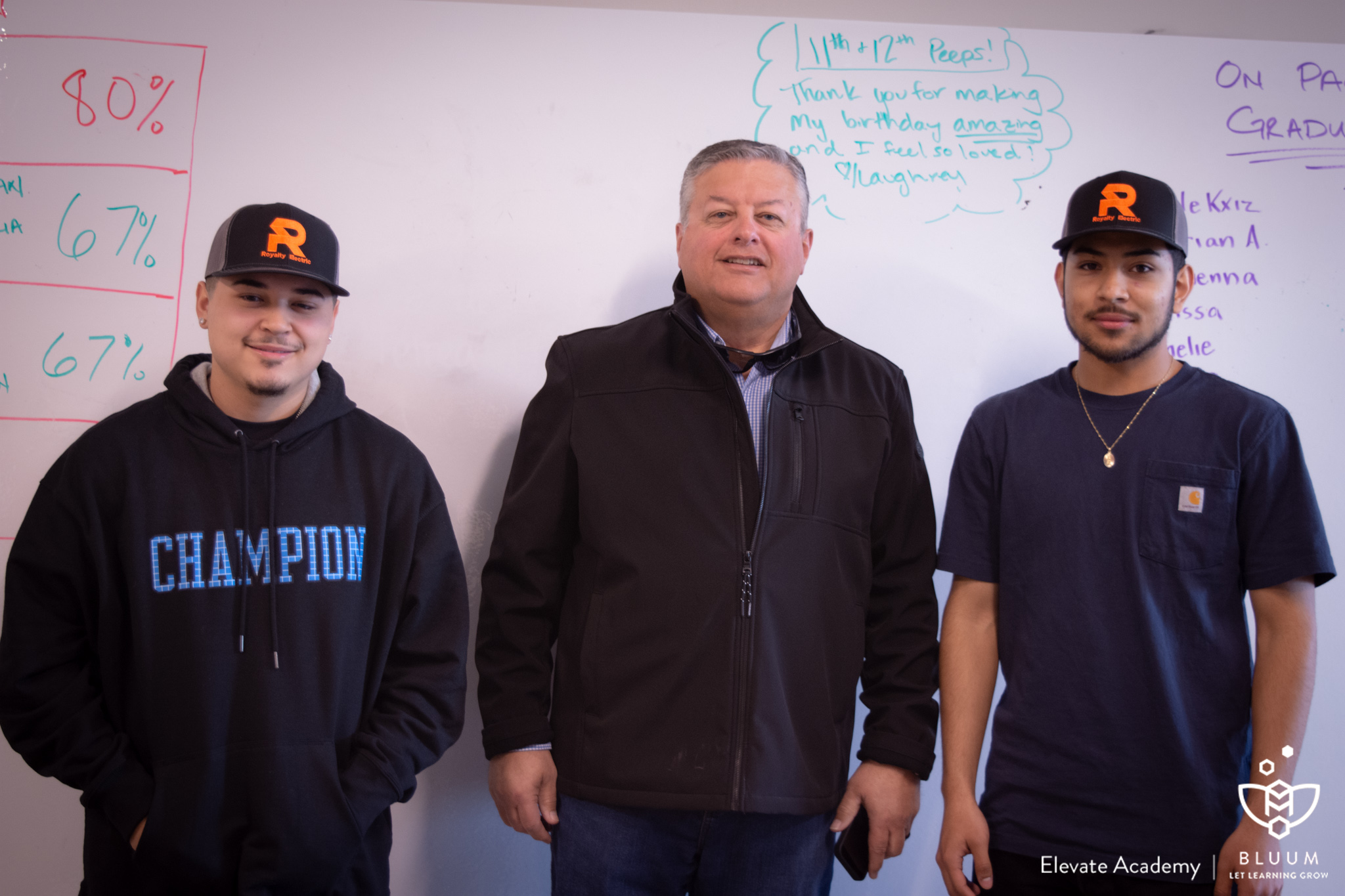 Senior Damian Garcia, Owner of Royalty Electric Steve Meistrell and Senior Mario Cabrera stand together. Before the signing, Meistrell gave the two students hats welcoming them to the Royalty team.